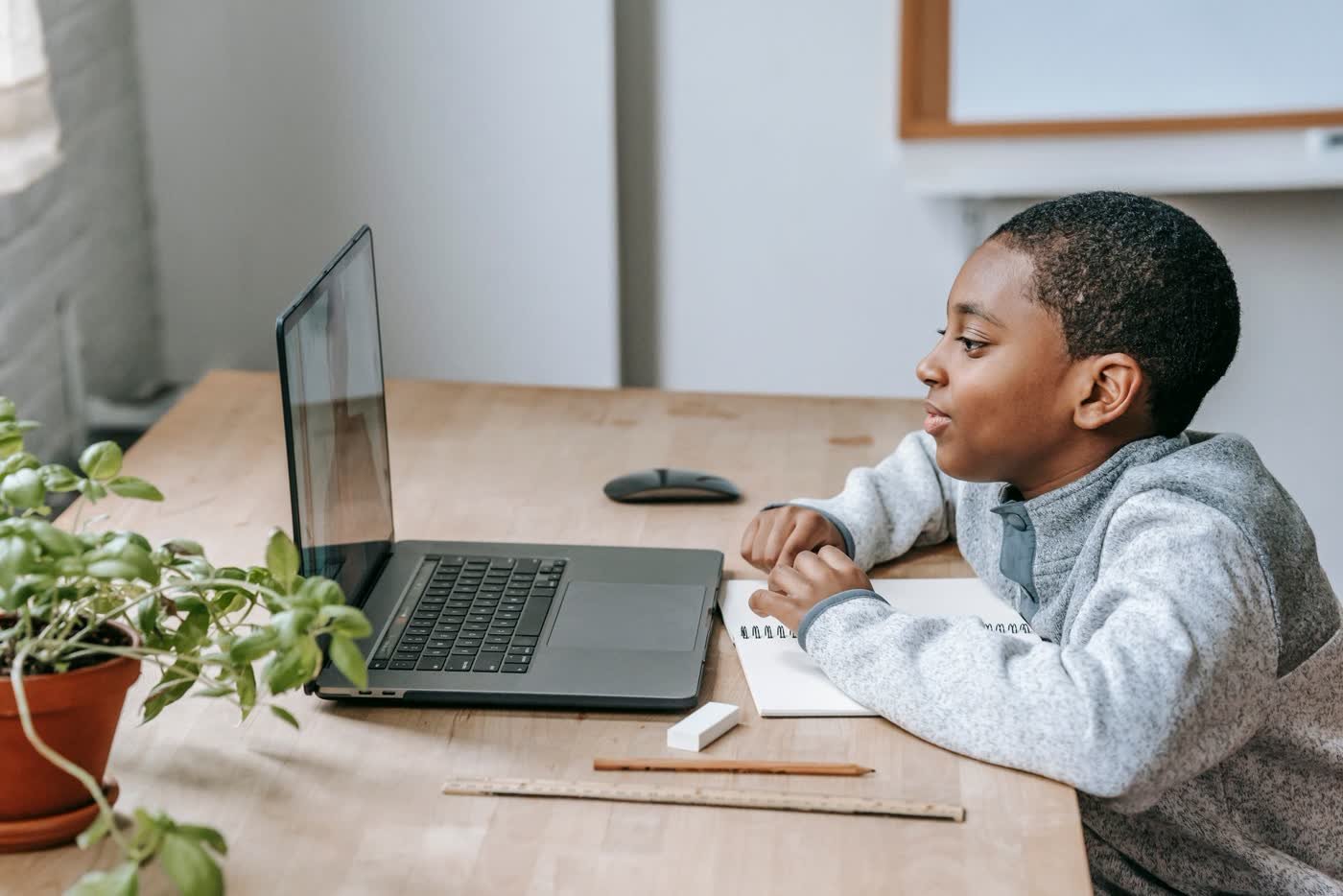 Enfant qui apprend à coder en ligne sur son ordinateur portable à la maison